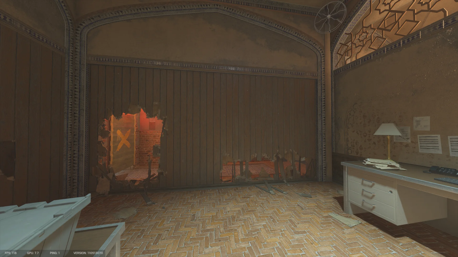 Arched room on Border 1F with a desk lamp and papers at right and a wooden partition breached at left, revealing a red-lit brick room and a yellow-X panel