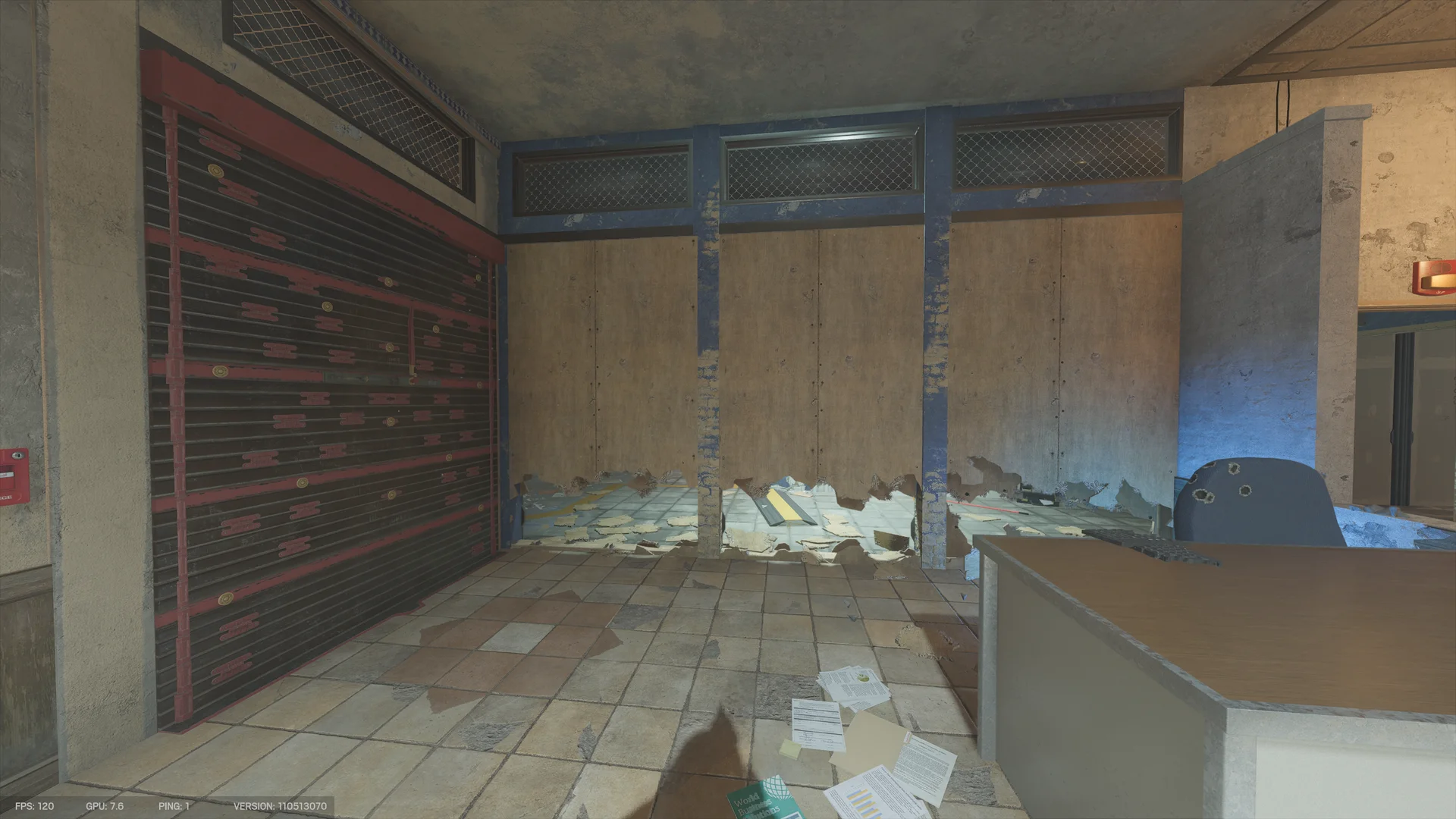 Tiled office on Border 1F with a closed metal shutter at left and a plywood-boarded partition torn open along its base, a desk and chair at right