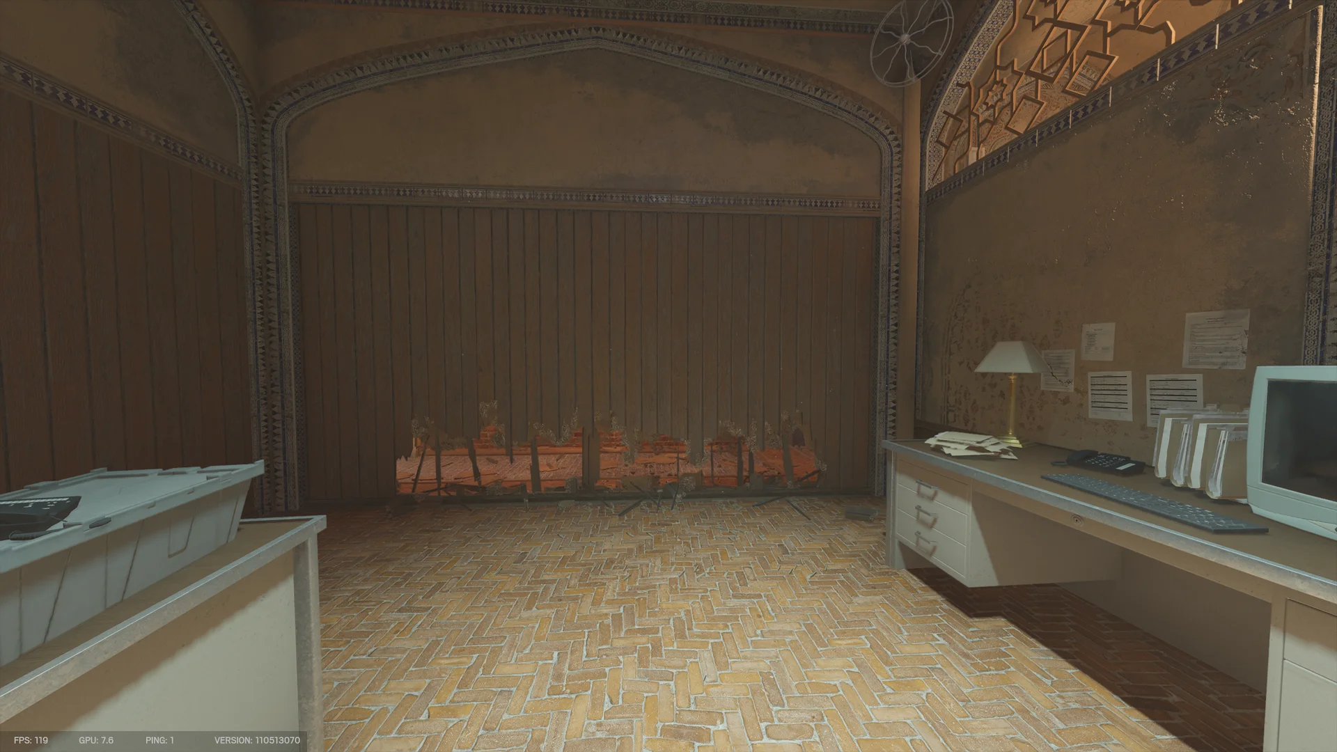 Arched office on Border 1F with a herringbone brick floor and a desk with a CRT monitor and lamp, facing a wooden wall breached along its base
