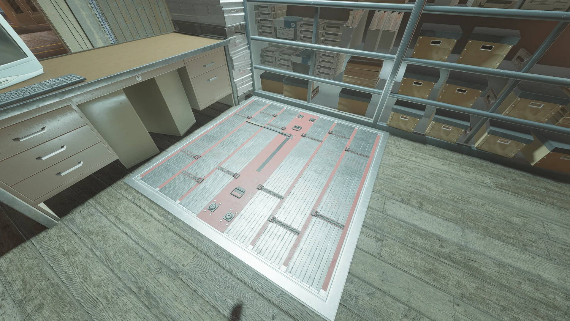 Closed metal floor hatch set into wooden floorboards on Border 1F, beside a desk with a CRT monitor and shelves of file boxes behind a railing