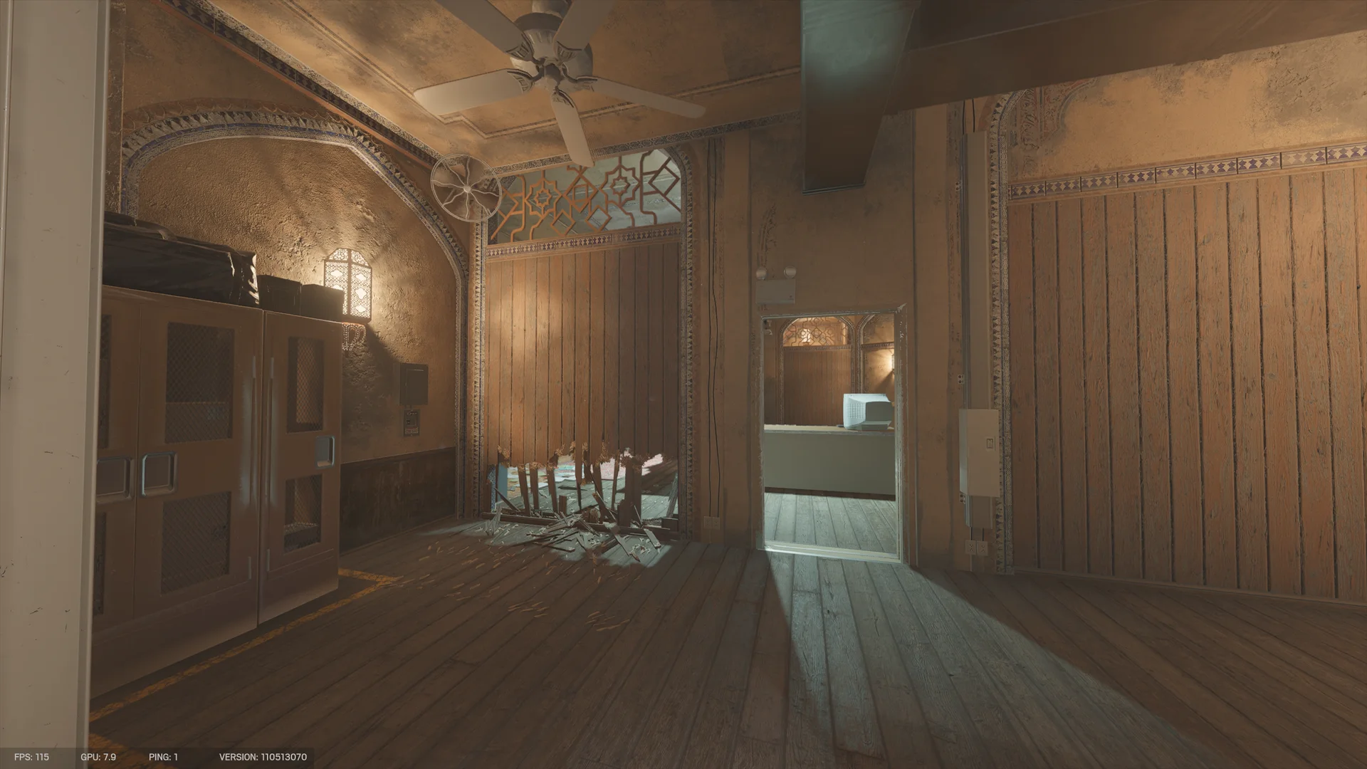 Ornate room on Border 1F with a ceiling fan, mesh-front cabinets, a splintered breach at the base of a wooden partition, and a doorway to a CRT monitor