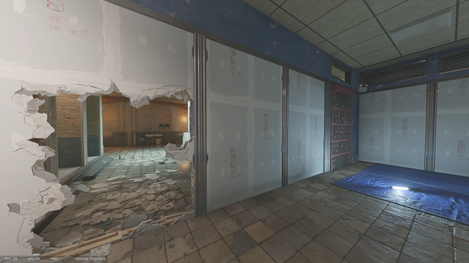 Drywall-lined room on Border 1F with a large ragged breach opening to a brick-walled tiled area, a dark metal shutter and a blue tarp with a light stick