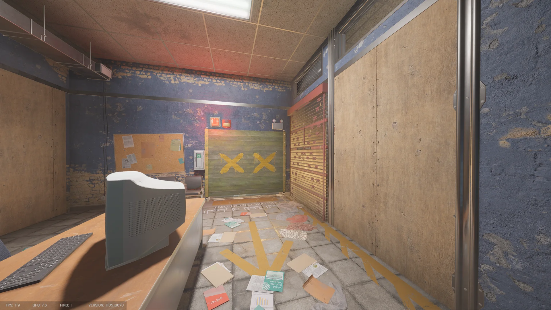 Room on Border 1F with a CRT monitor on a desk, a corkboard, a green panel marked with two yellow X's, a metal shutter, and painted arrows on the floor