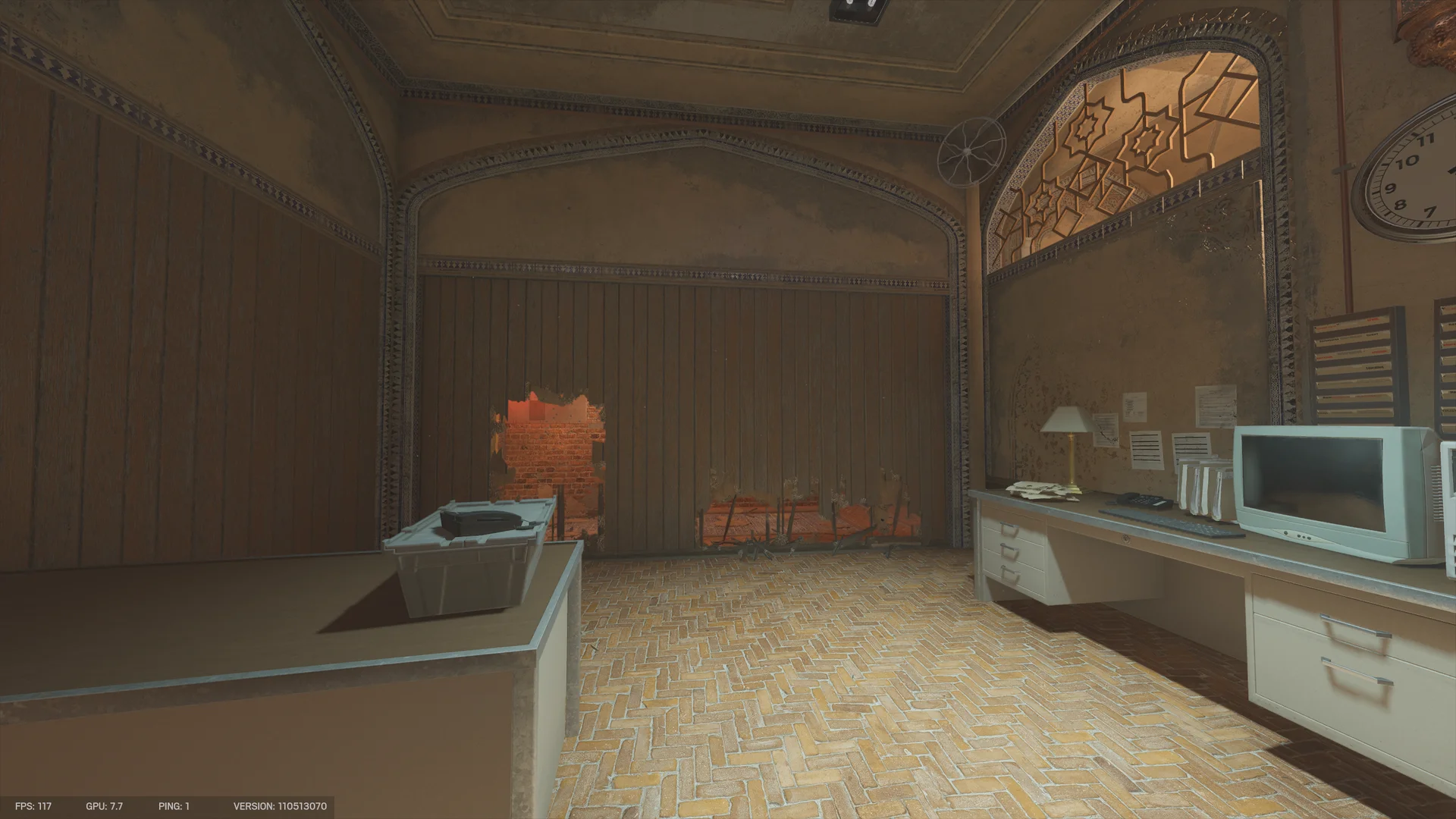 Office on Border 2F with a herringbone brick floor, a desk with a CRT monitor, and low jagged holes in a wooden wall showing red brick beyond