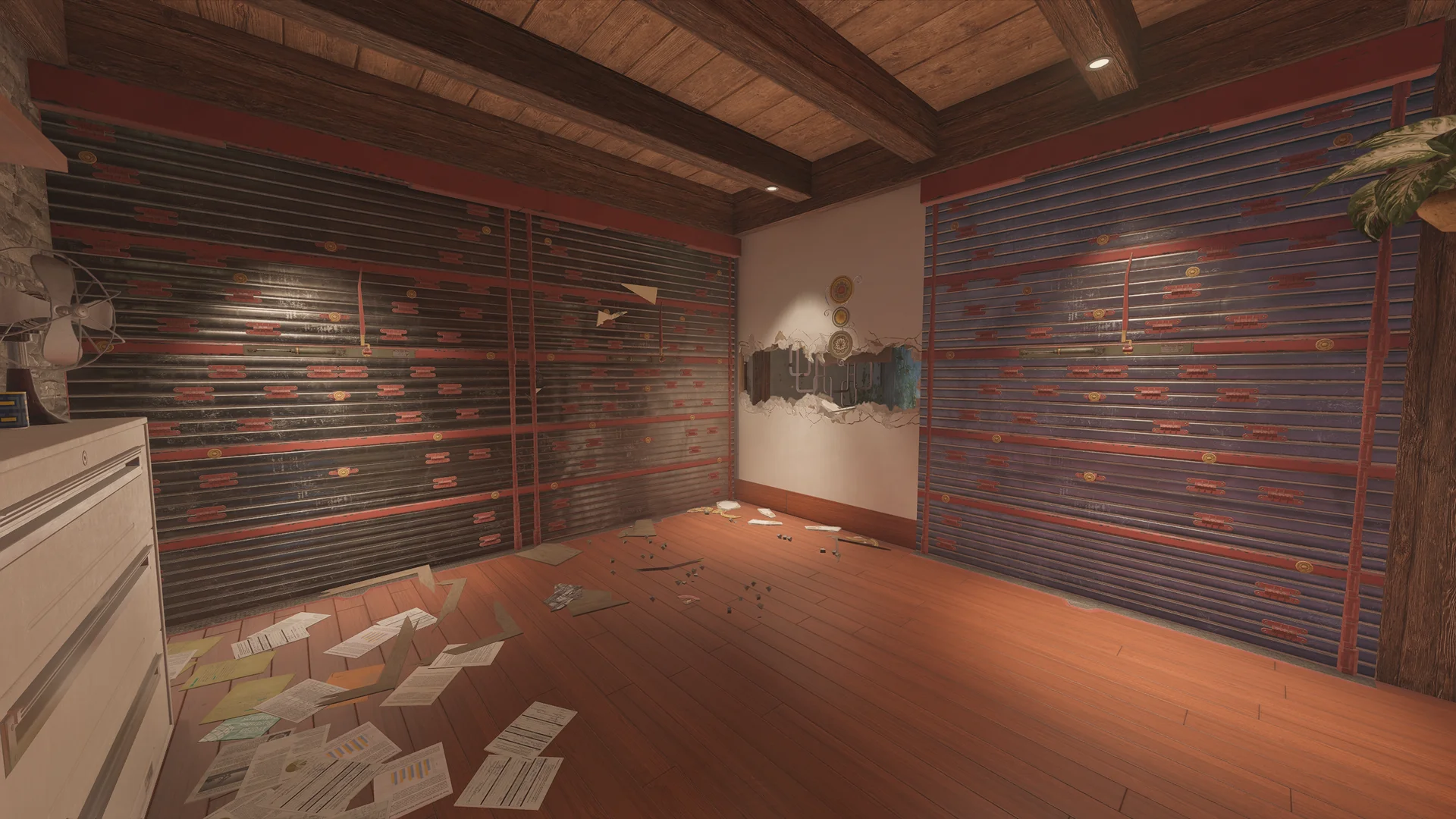 Room on Chalet 1F with two reinforced walls around a breached corner, a metal fan and cabinet at left and papers below