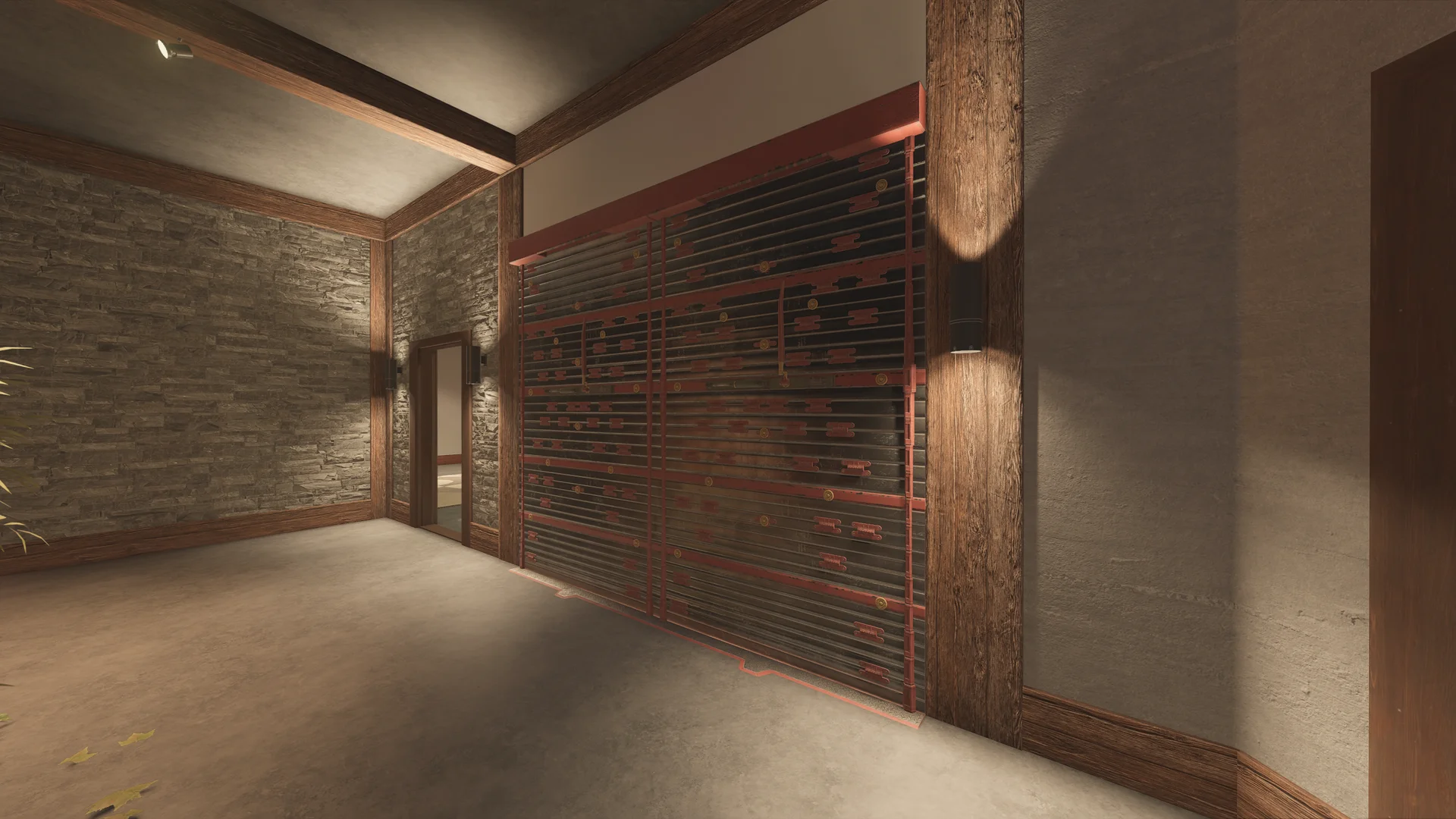 Concrete-floored room on Chalet 1F with a wide reinforced wall between wooden posts, wall lamps and a stone wall at left