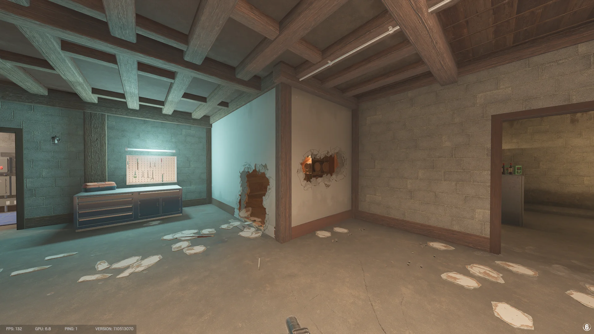Workshop in the Chalet basement with a tool pegboard and workbench, and two wall breaches revealing a barrel room beyond
