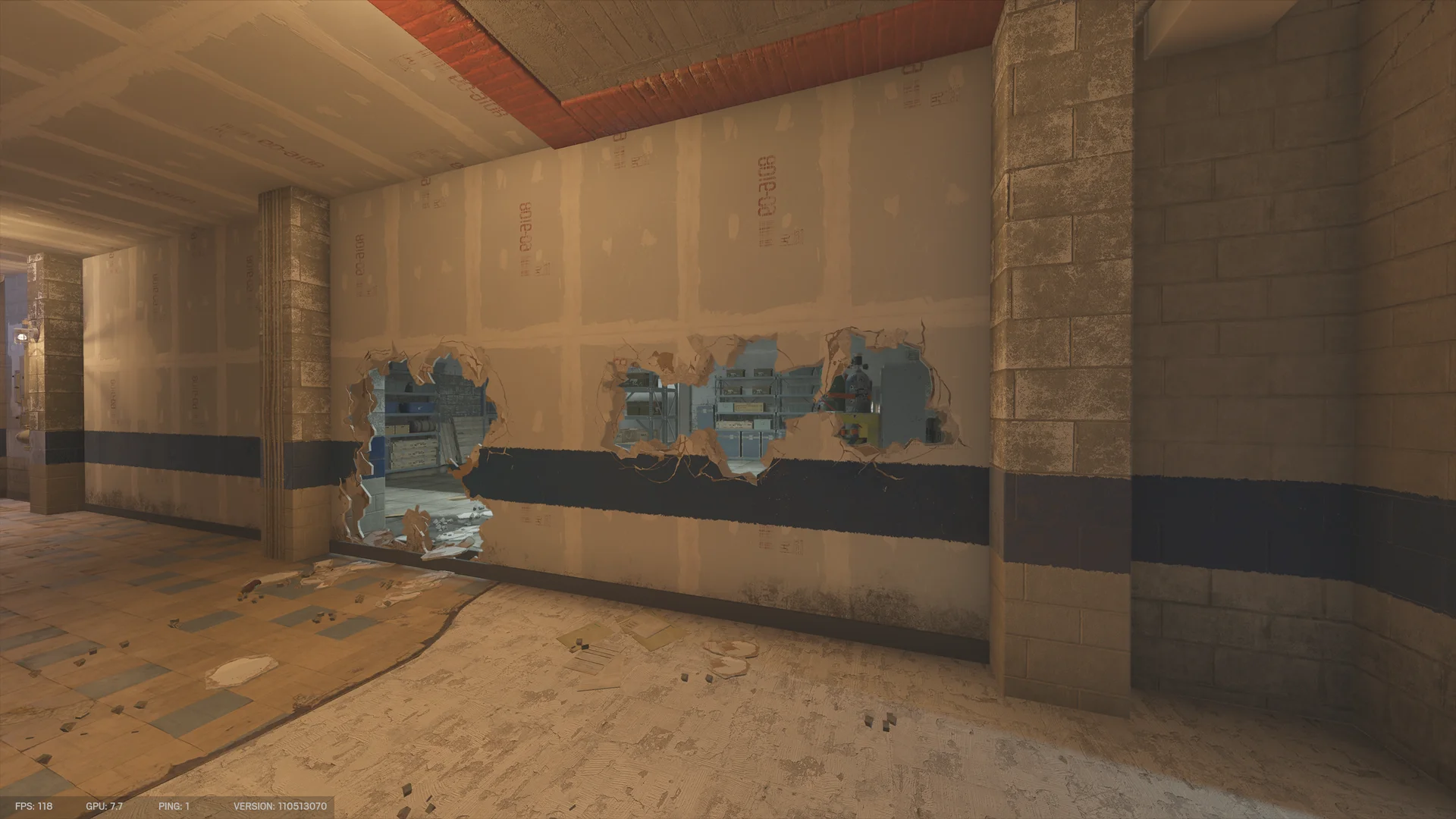 Hallway in the Club House basement with several breach holes through a drywall wall, opening to a storeroom with shelving and crates