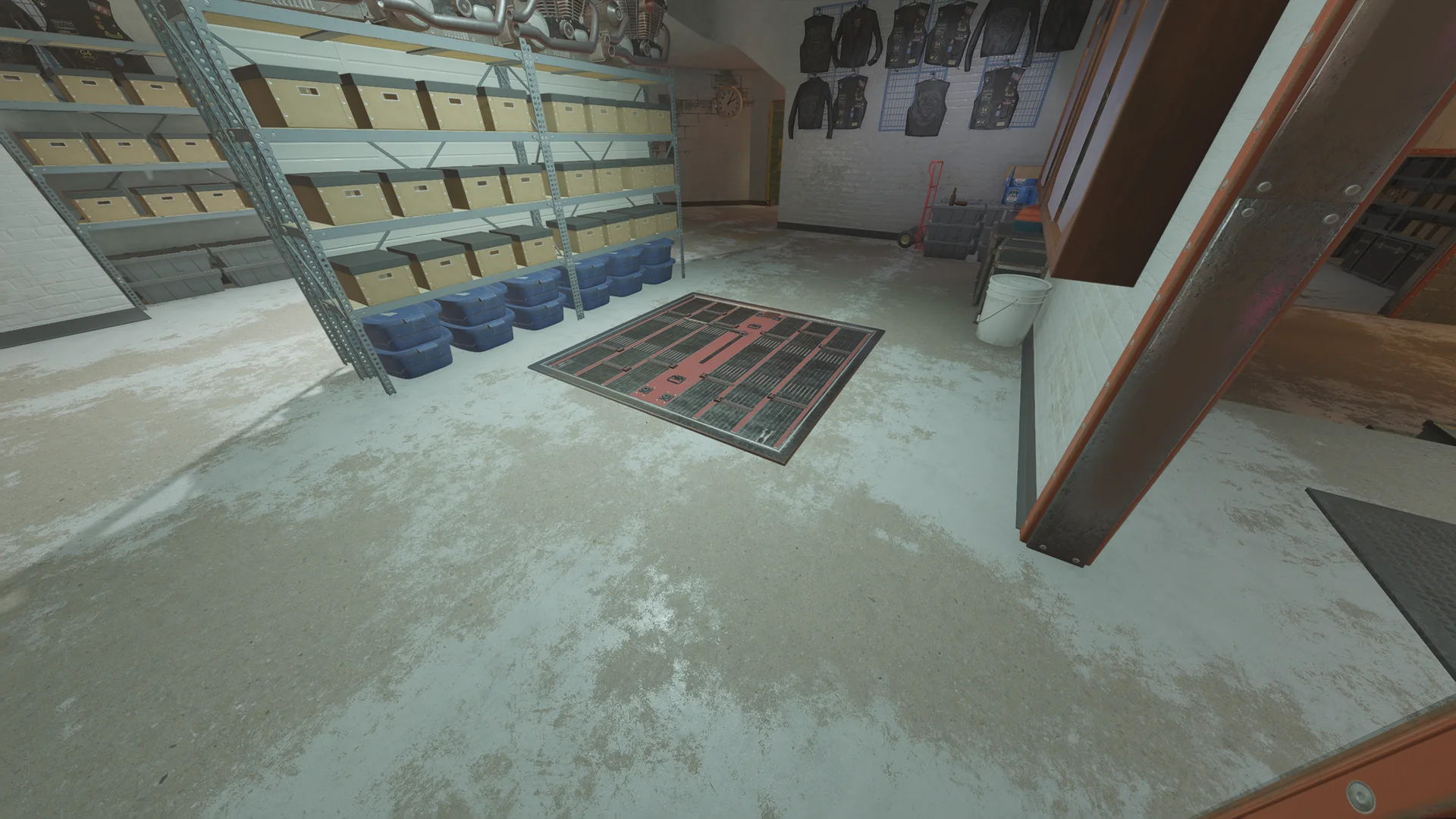 Garage in the Club House basement with a reinforced floor hatch, metal shelving of file boxes and bins, and jackets hung on the wall