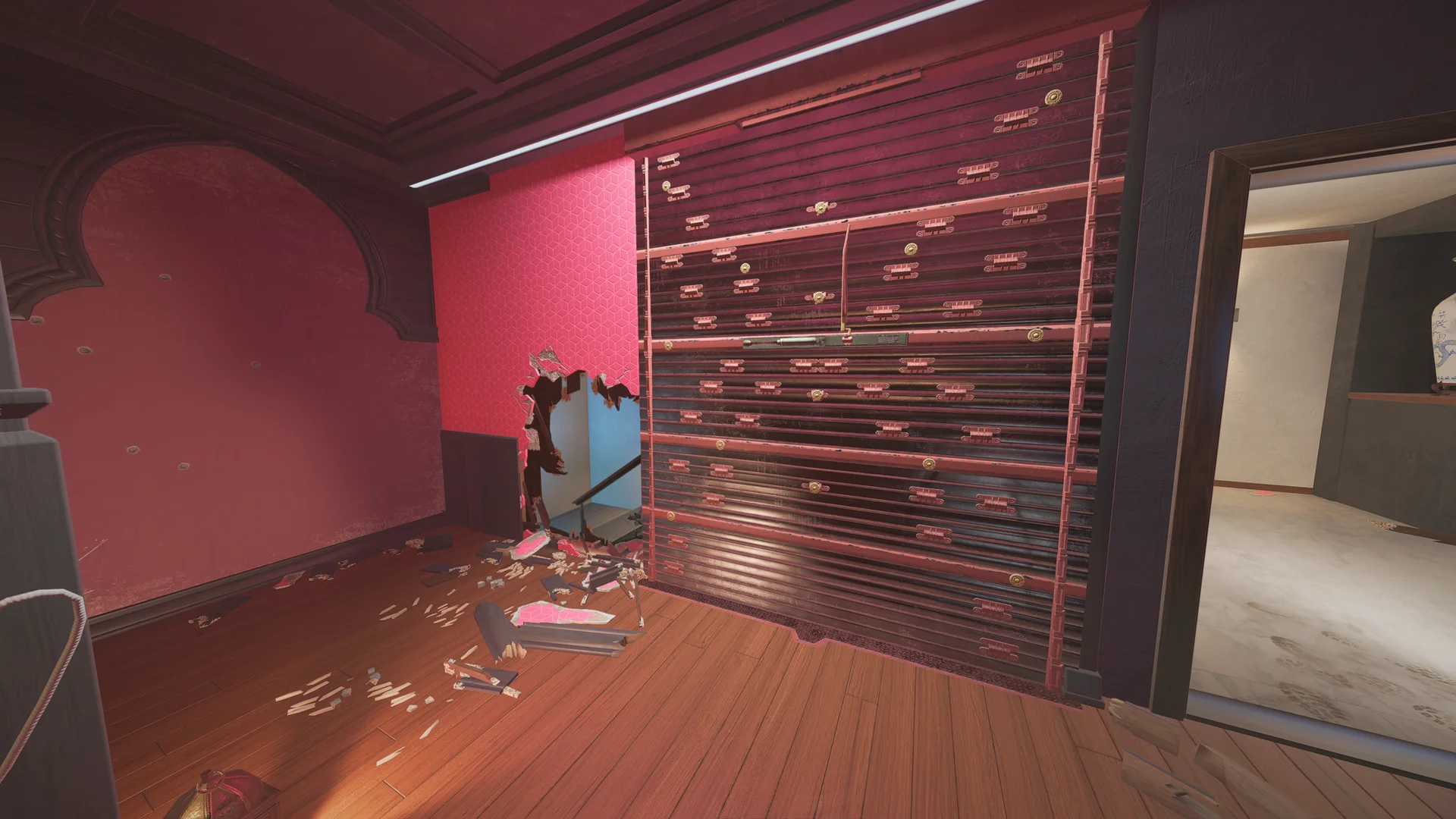 Dark red room on Coastline 2F with a reinforced shutter wall and a breach hole through a pink-tiled wall to a blue stairwell beyond