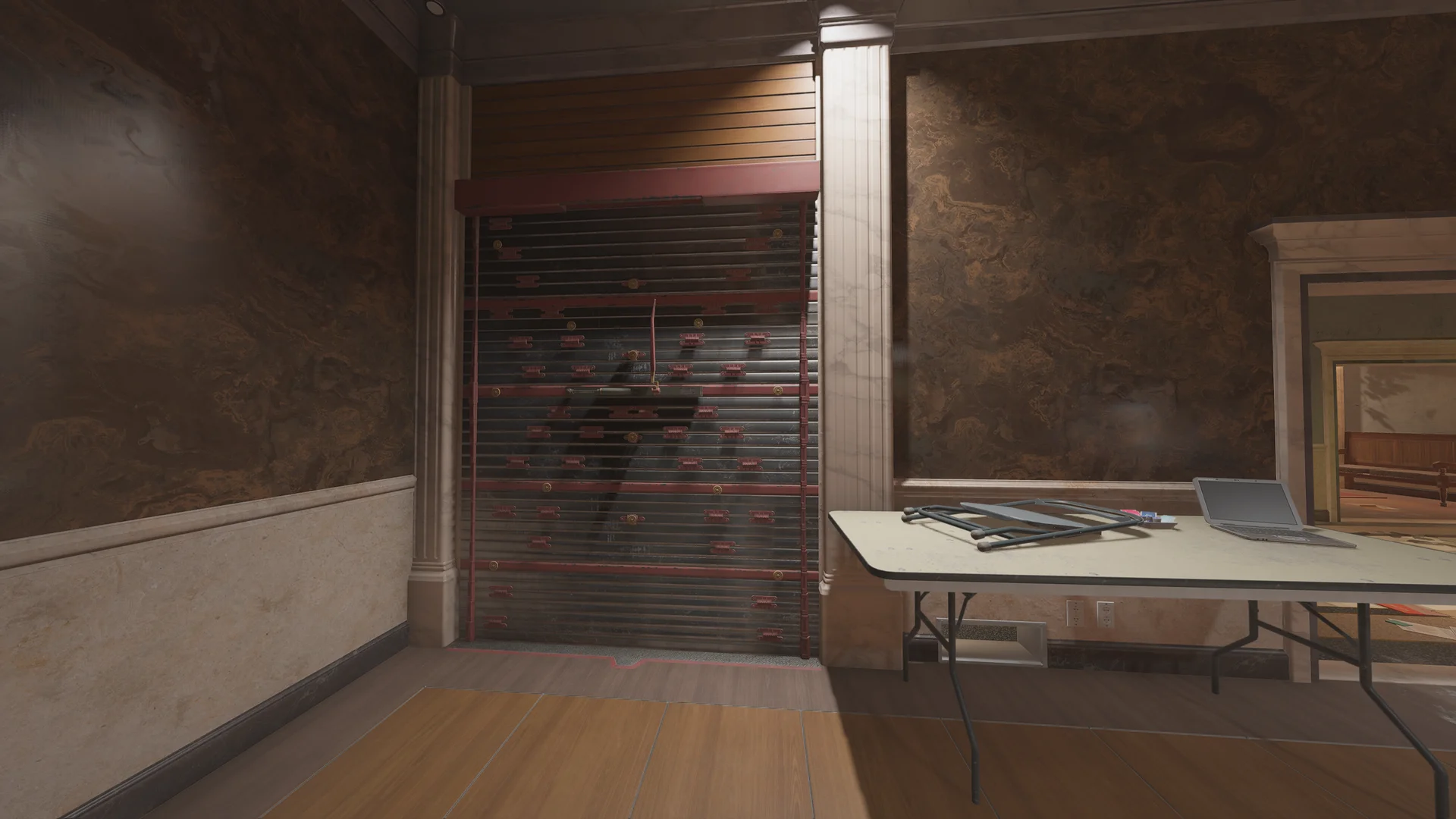 Ornate room on Consulate 2F with a reinforced shutter wall, marbled walls, and a folding table holding a laptop at right