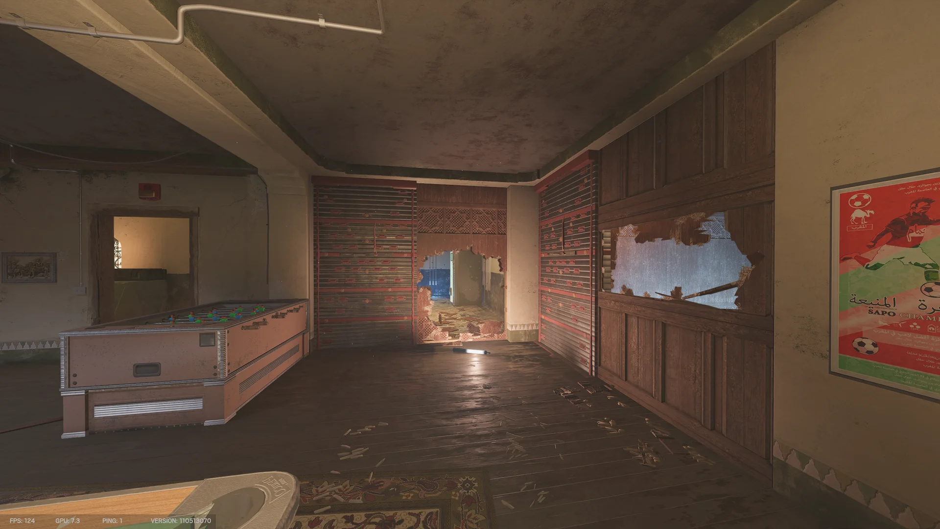 Games room on Fortress 2F with a foosball table, two reinforced shutters, breach holes through the walls, and a soccer poster on the right