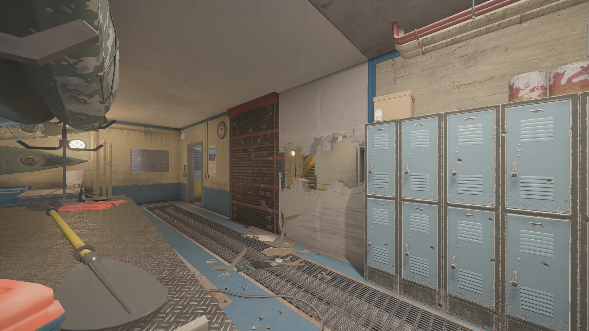 Equipment room in the Kanal basement with a boat and kayak on racks, a reinforced shutter, a tool pegboard, blue lockers, and a floor grate