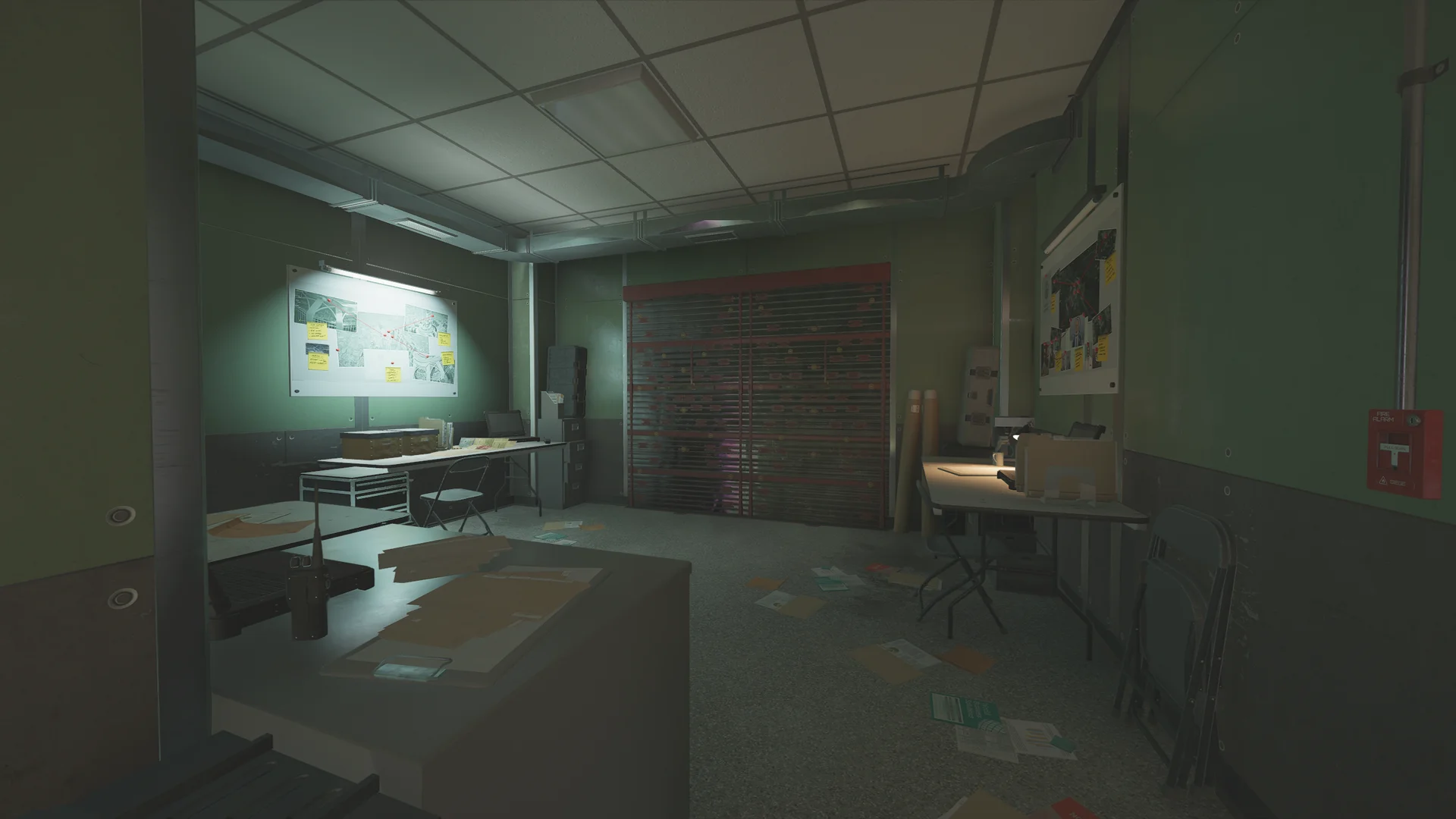 Dim planning room on Lair 1F with a lit pinboard of photos and notes, desks, a reinforced shutter, and papers scattered on the floor