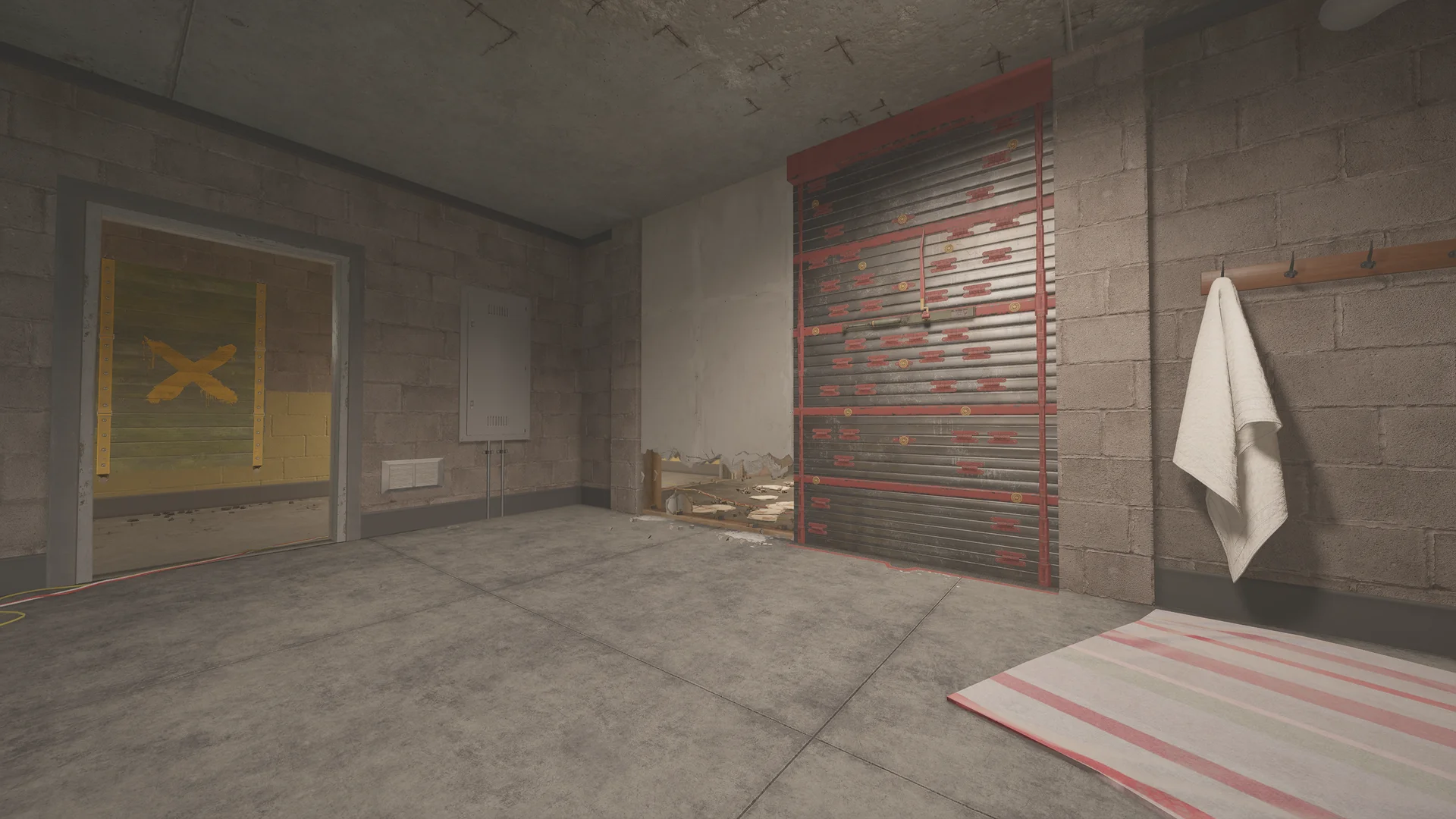 Cinder-block room on Oregon 1F with a reinforced shutter beside a low breached wall, a towel on wall hooks and a rug