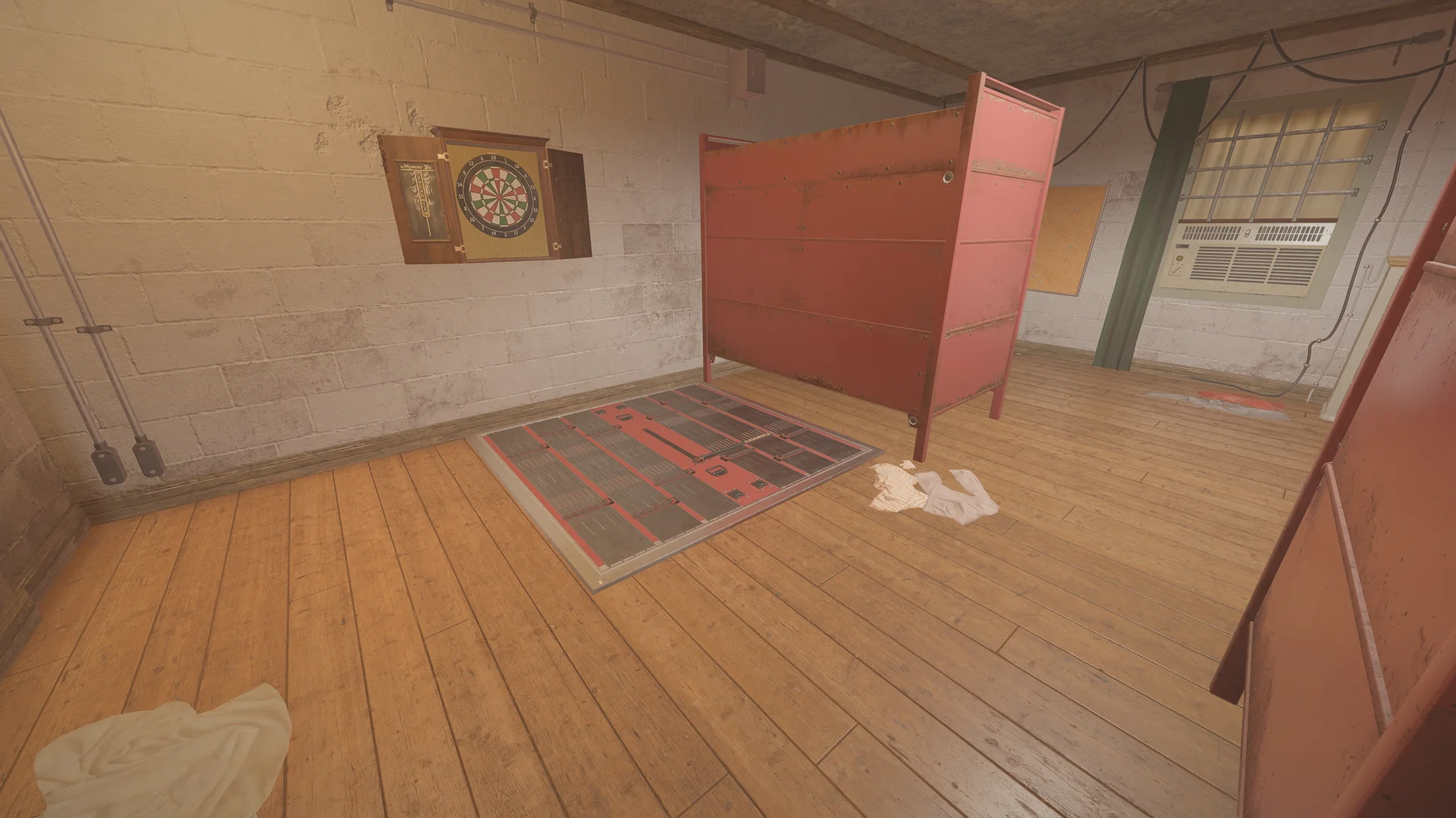 Room on Oregon 1F with a dartboard on a whitewashed block wall and a red metal frame beside a reinforced floor hatch