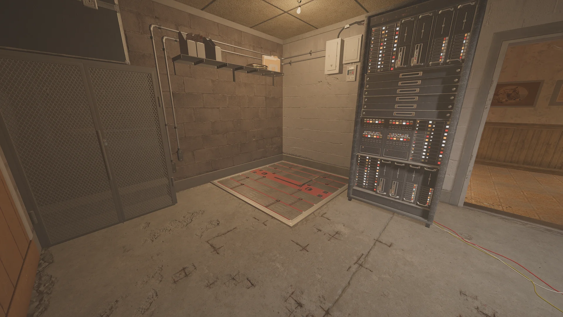 Room in the Oregon basement with a tall electronics rack, mesh cage doors and a reinforced floor hatch in the corner