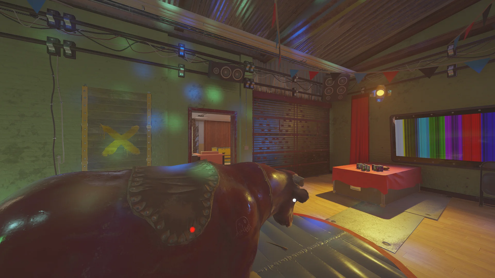Party room on Outback 2F with a mechanical bull, bunting and speakers, a reinforced shutter and a TV showing color bars