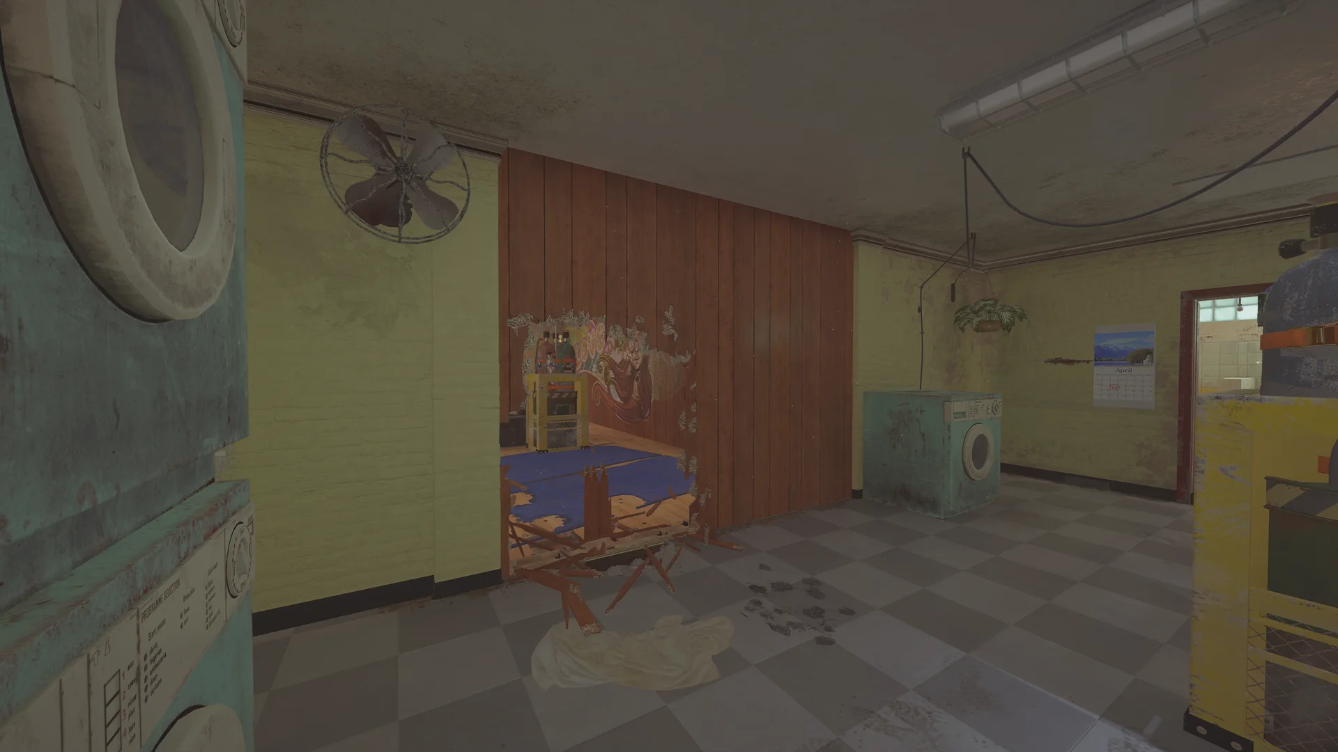 Laundry room on Outback 2F with washing machines, a wall fan and a breach in wood panelling opening to a mural room