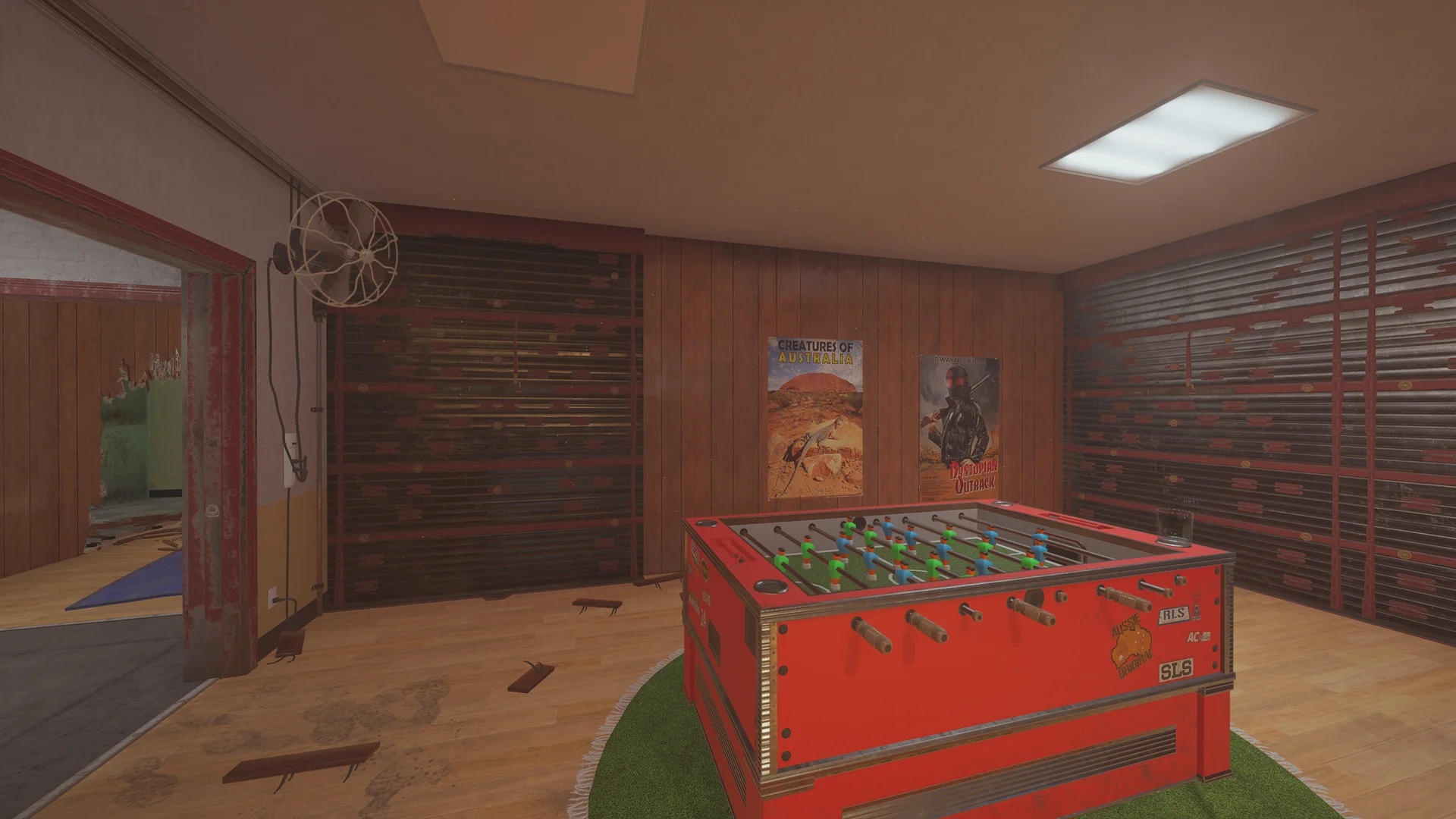 Games room on Outback 2F with a red foosball table on a round rug, film posters and two reinforced shutter walls