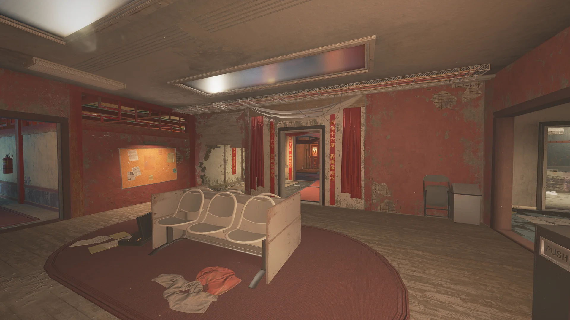 Worn red waiting room on Theme Park 2F with white plastic chairs on an oval rug, a corkboard, and banners beside a doorway