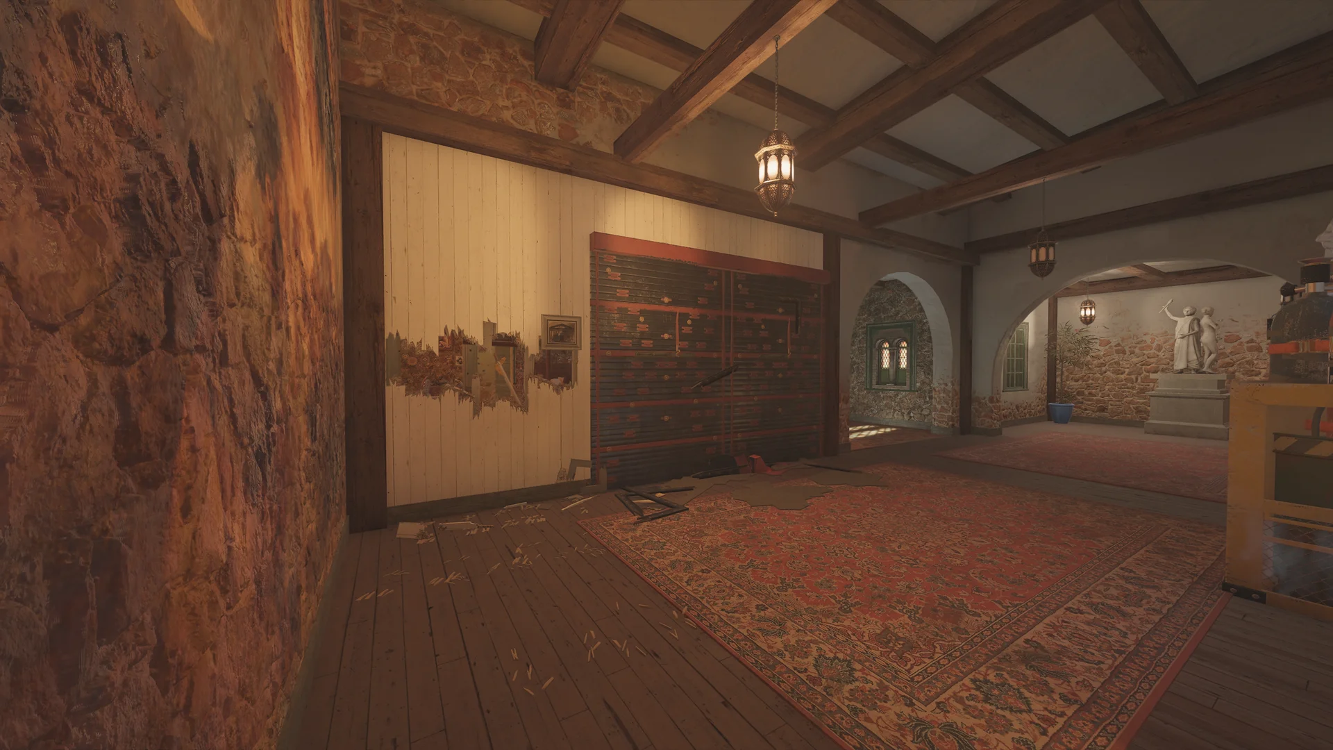 Large room on Villa 1F with a patterned red rug, a slatted wall panel, a hanging lantern, and an arch to a room with a statue